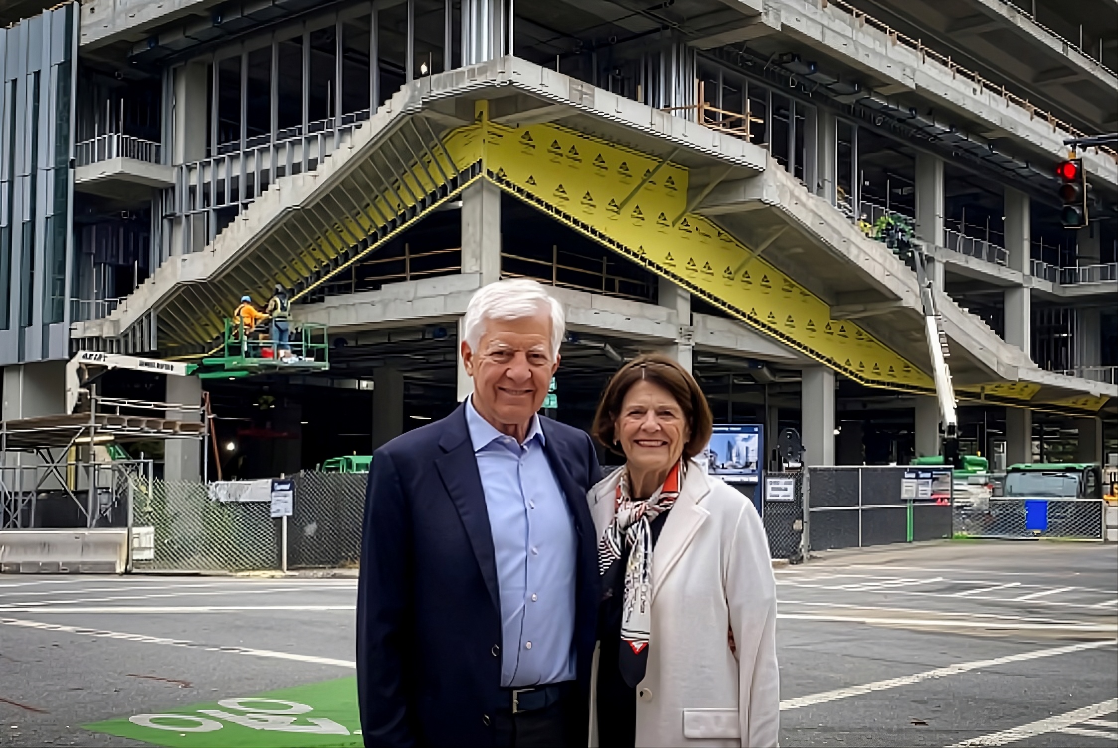 Bill and Penny George standing in front of George Tower under construction